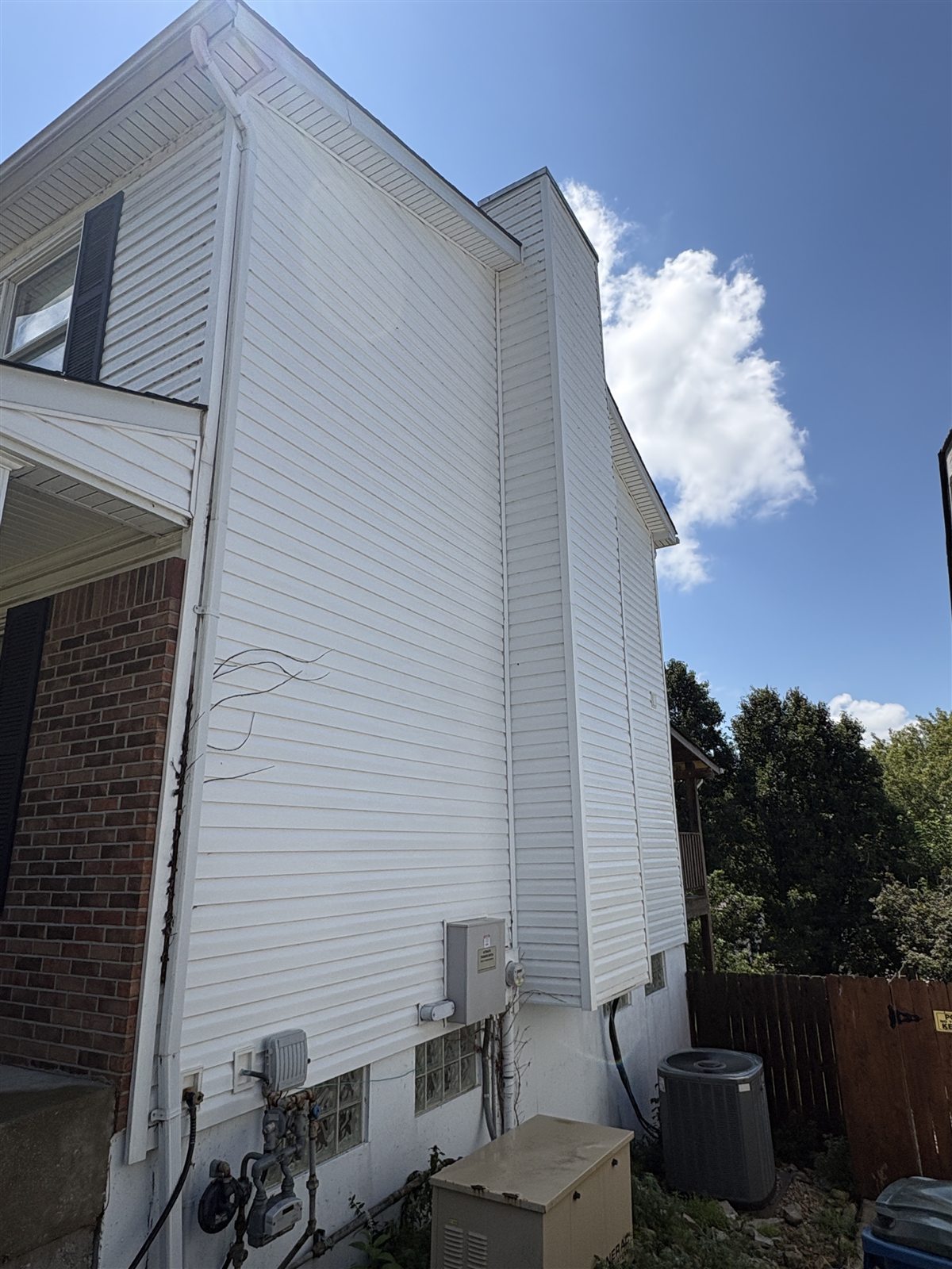 Two-story vinyl siding after soft washing, with a clean white finish